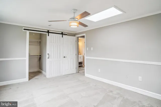 an empty room with a window and a ceiling fan