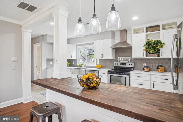 a kitchen with stainless steel appliances granite countertop a stove and a wooden floors