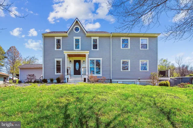 a front view of a house with a yard and plants