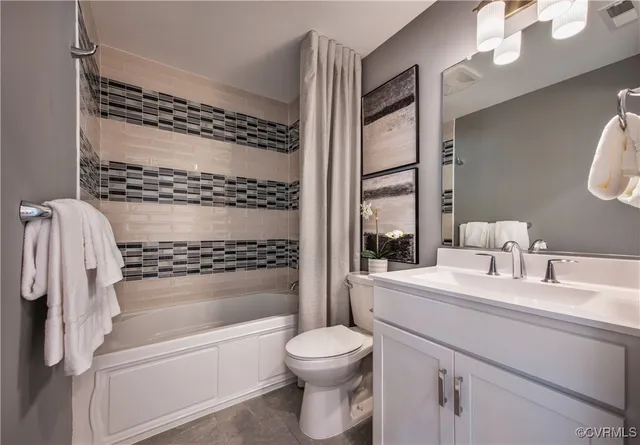 a bathroom with a bathtub shower sink vanity and toilet