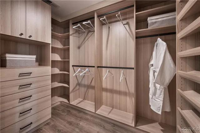 a view of walk in closet with clothes and shoes