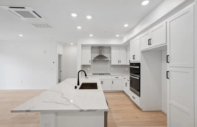 a kitchen with a sink stainless steel appliances and white cabinets
