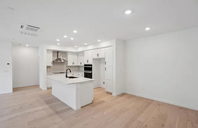 a open kitchen with white cabinets and white stainless steel appliances