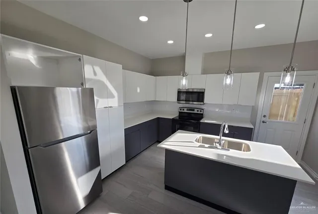 a kitchen with refrigerator cabinets and wooden floor