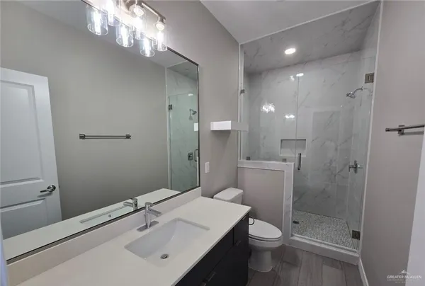 a bathroom with a sink a toilet and shower