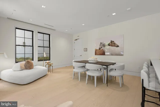 a dining room with furniture and a large window