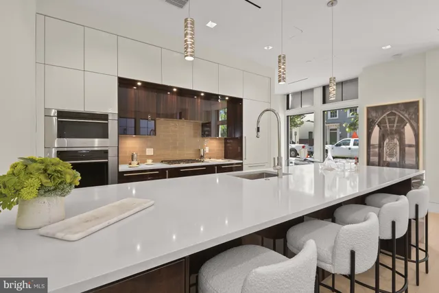 a large kitchen with stainless steel appliances a large counter top