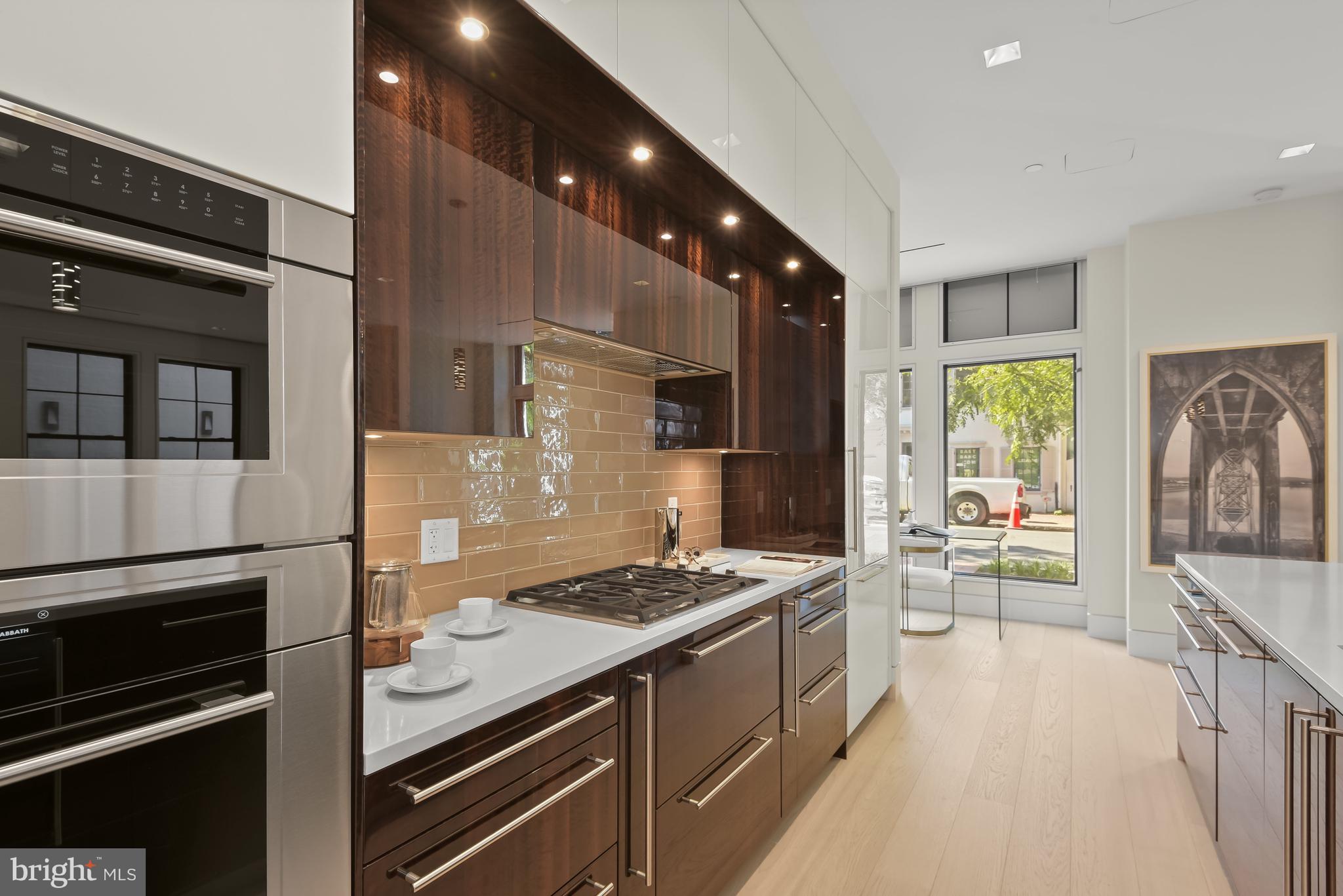 3255 Prospect Street Northwest, Unit ONE Washington, DC 20007 - Photo 9 of 18 a kitchen with stainless steel appliances kitchen island granite countertop a stove and a refrigerator