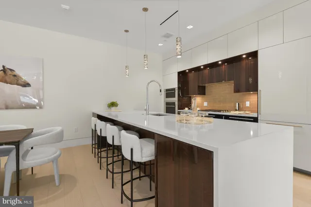 a kitchen with stainless steel appliances a sink a table and chairs