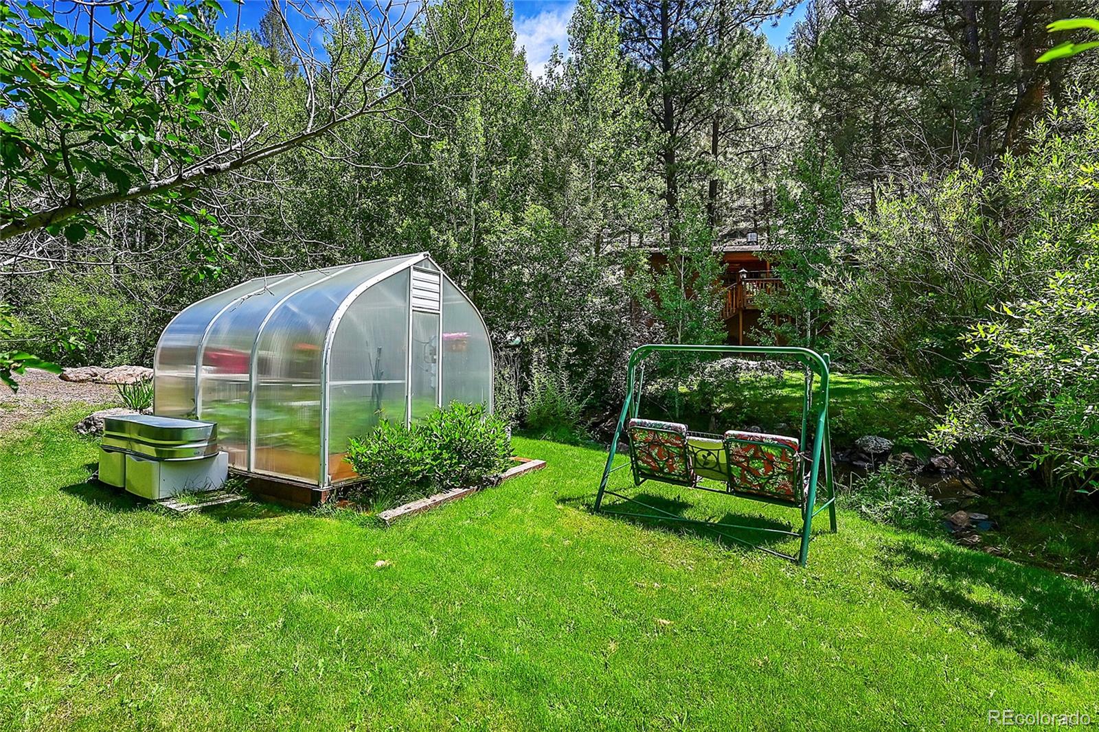 14432 South Elk Creek Road Pine, CO 80470 - Photo 23 of 50 a view of a backyard with potted plants and large trees