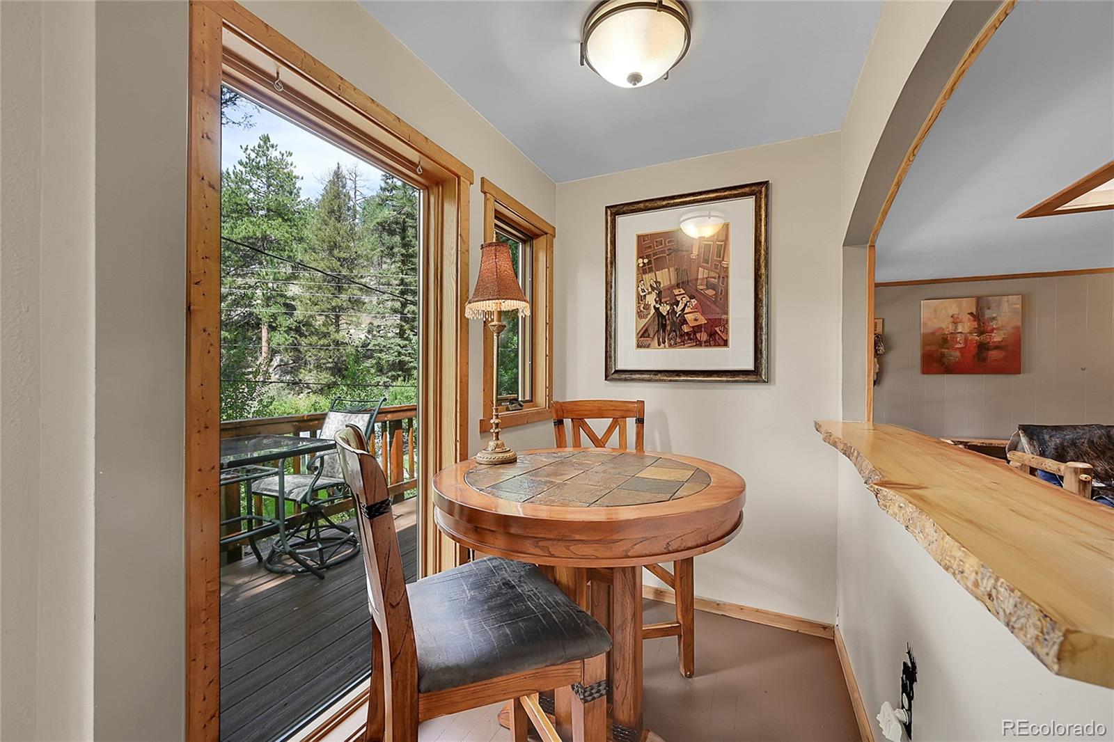 14432 South Elk Creek Road Pine, CO 80470 - Photo 33 of 50 a view of a dining room with furniture a chandelier and wooden floor
