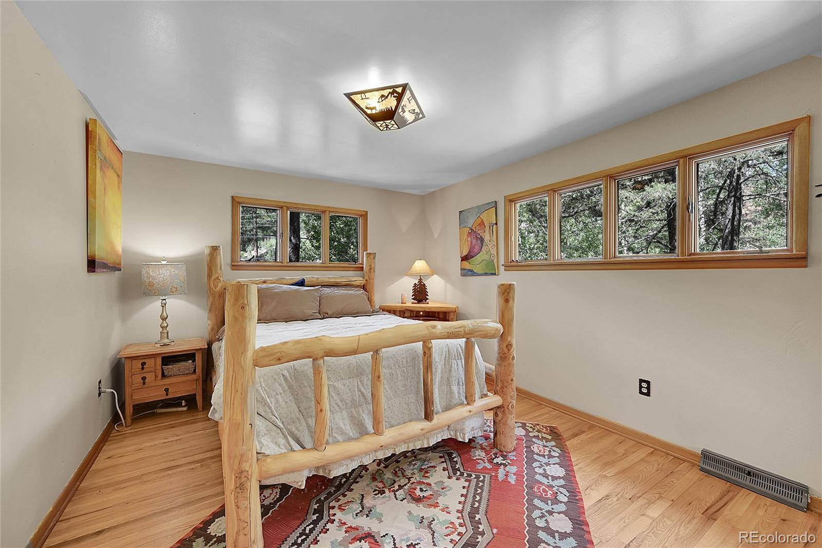 14432 South Elk Creek Road Pine, CO 80470 - Photo 40 of 50 a bedroom with a bed a rug and wooden floor