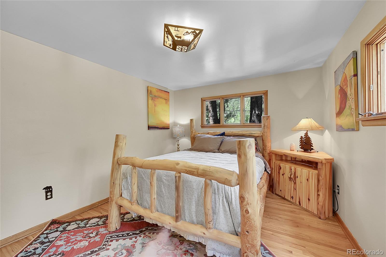 14432 South Elk Creek Road Pine, CO 80470 - Photo 41 of 50 a bedroom with a bed and wooden floor