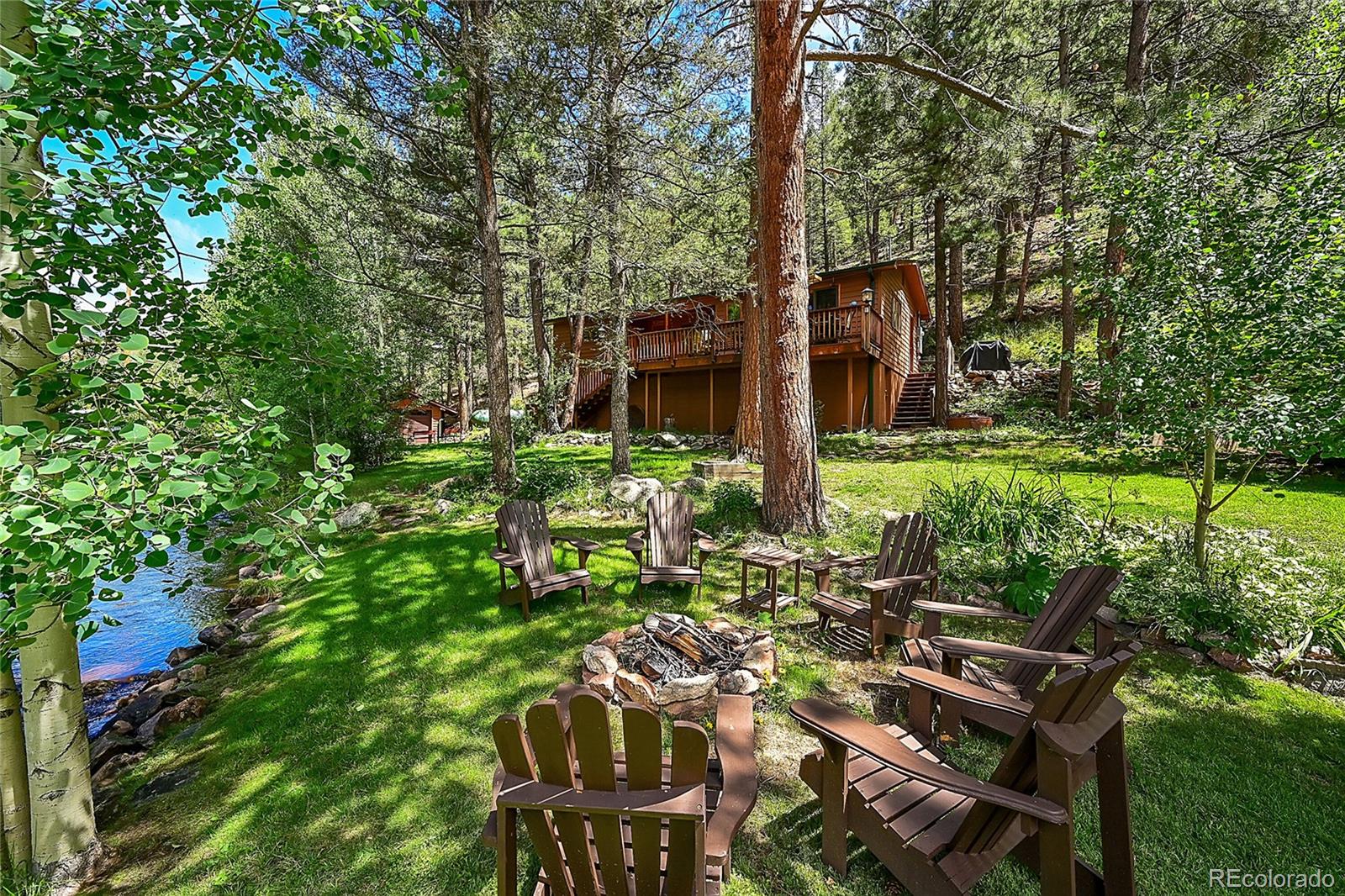 14432 South Elk Creek Road Pine, CO 80470 - Photo 6 of 50 a view of backyard with table and chairs and a large tree