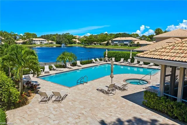 a view of a swimming pool with a table and chairs under an umbrella