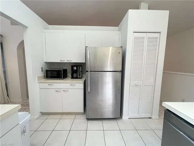 a white refrigerator freezer and a stove sitting inside of a kitchen