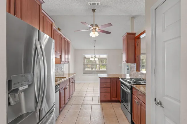 a kitchen with stainless steel appliances a stove a refrigerator and a sink