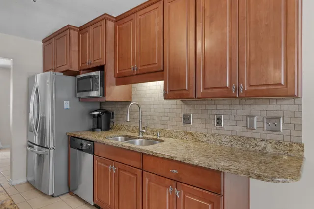 a kitchen with stainless steel appliances granite countertop a refrigerator sink and cabinets