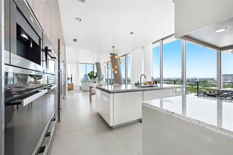 a kitchen with counter top and living room
