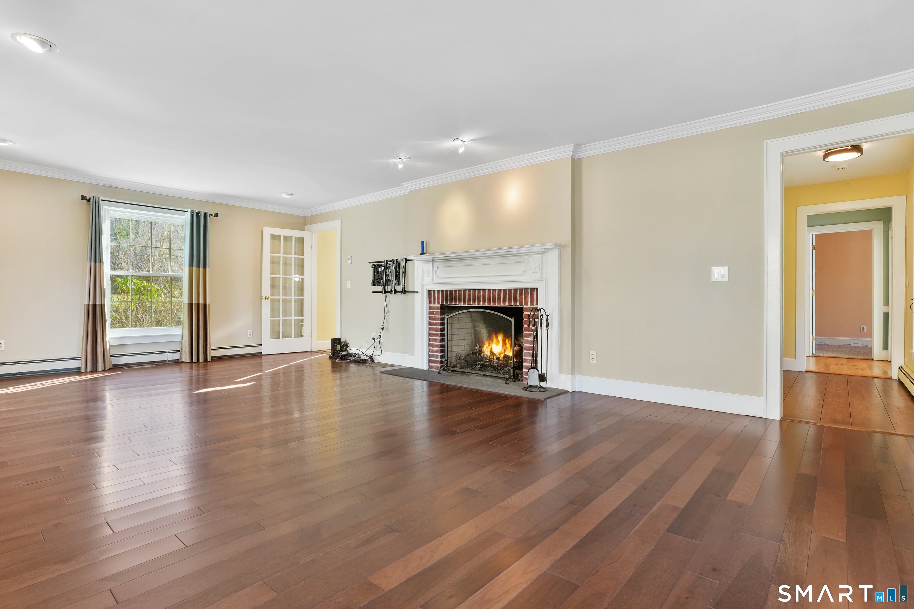 297 Long Mountain Road New Milford, CT 06776 - Photo 19 of 40 a view of an empty room with window and wooden floor