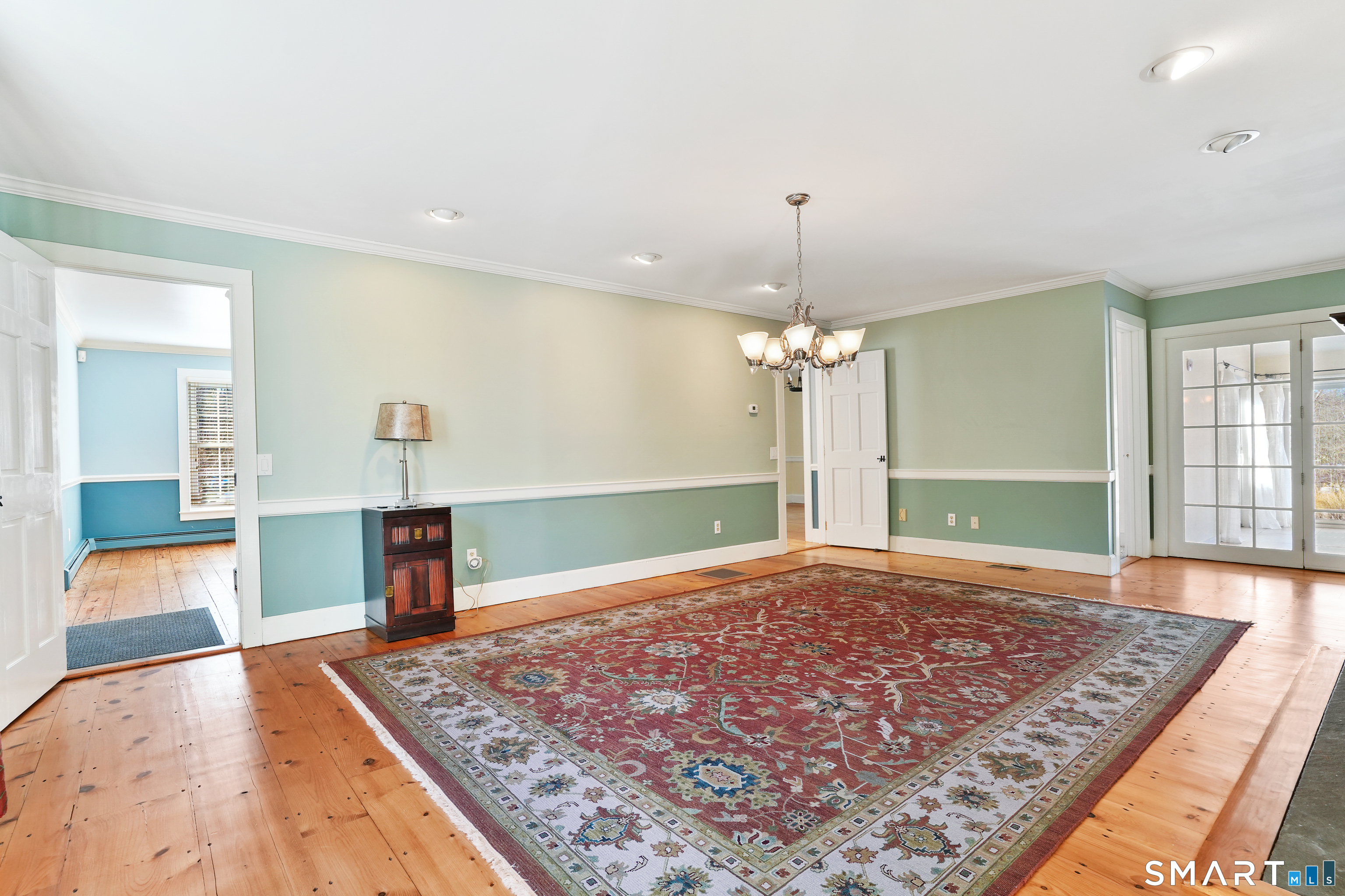 297 Long Mountain Road New Milford, CT 06776 - Photo 22 of 40 a view of a kitchen with kitchen island a sink wooden floor and a chandelier