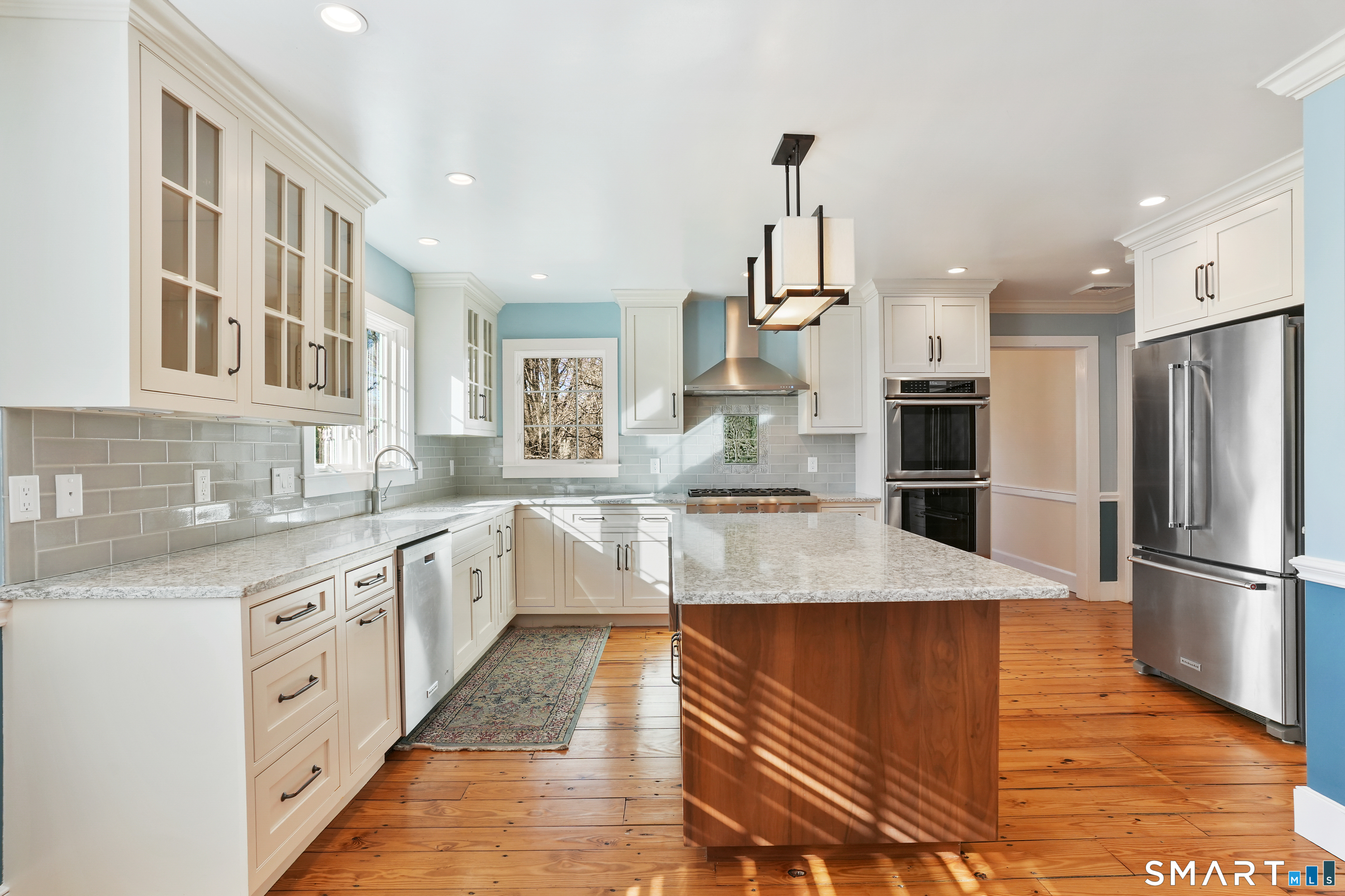 297 Long Mountain Road New Milford, CT 06776 - Photo 9 of 40 a large kitchen with stainless steel appliances kitchen island granite countertop a refrigerator a stove and white cabinets with wooden floors