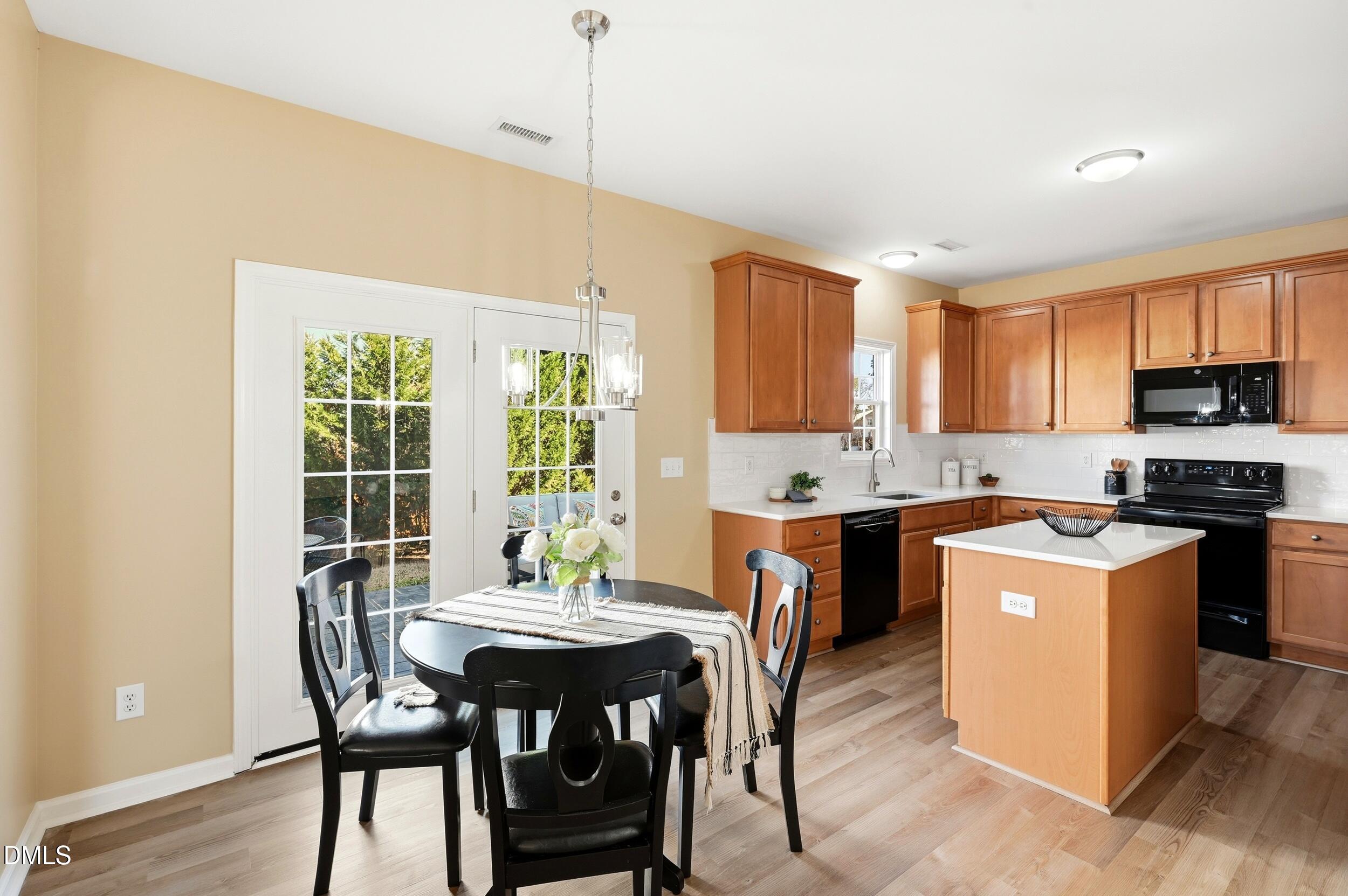 5401 Onyx Mill Court Raleigh, NC 27616 - Photo 17 of 48 a kitchen with a table chairs sink and cabinets