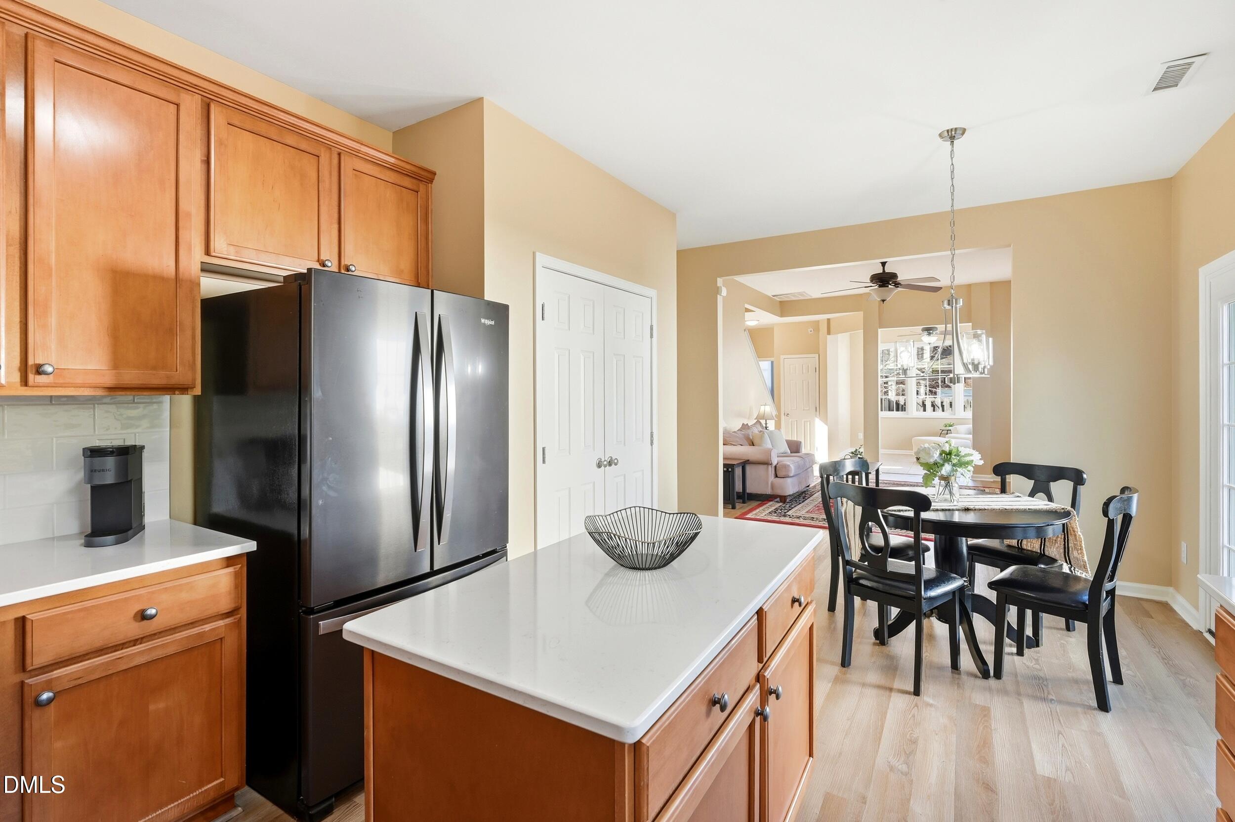 5401 Onyx Mill Court Raleigh, NC 27616 - Photo 22 of 48 a kitchen with stainless steel appliances granite countertop a refrigerator a stove a sink a dining table and chairs with wooden floor