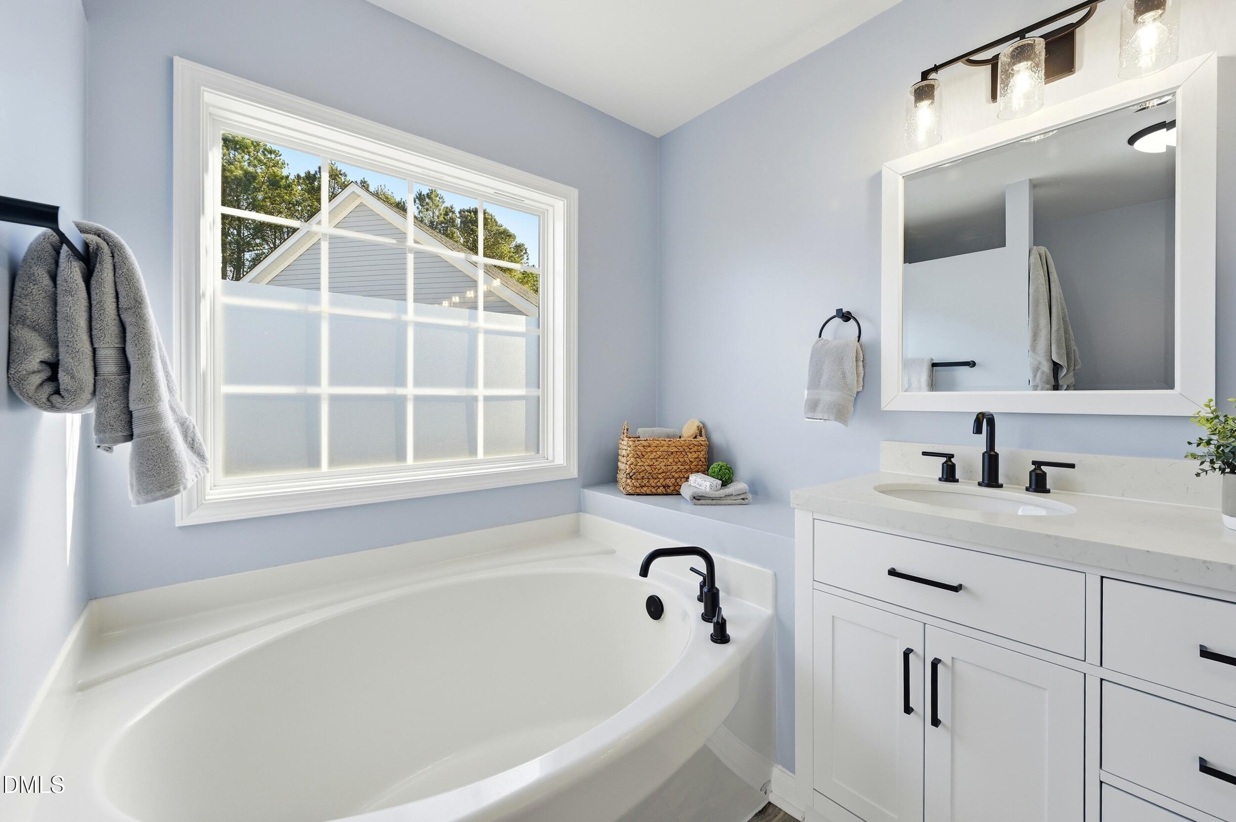 5401 Onyx Mill Court Raleigh, NC 27616 - Photo 27 of 48 a bathroom with a tub sink and a window