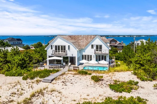 a view of a house with a big yard plants and large trees
