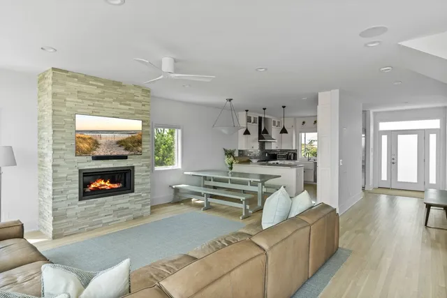 a living room with furniture a fireplace and wooden floor
