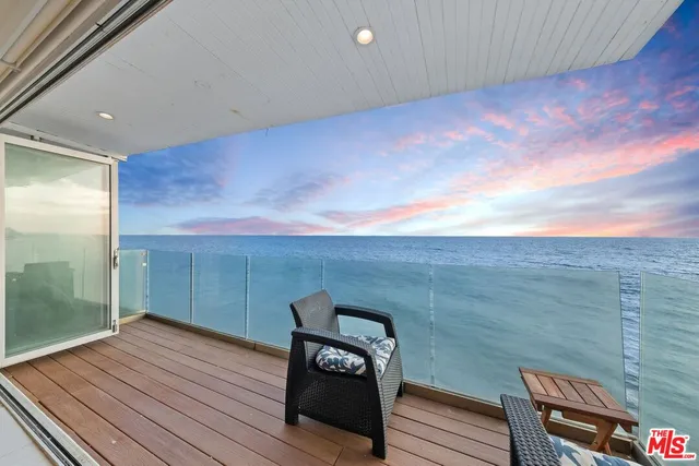 a view of a balcony with wooden floor and bench