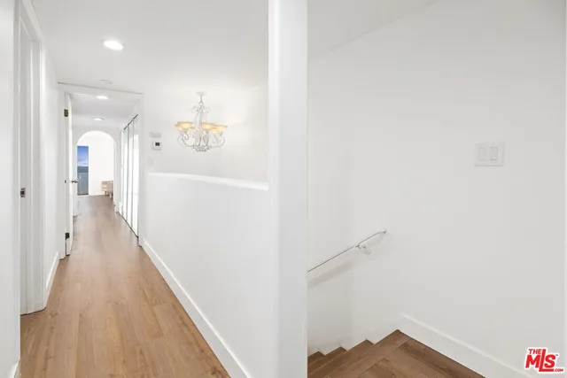 a view of a hallway with wooden floor and staircase