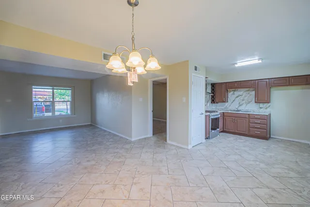 a view of a kitchen with a sink and chandelier