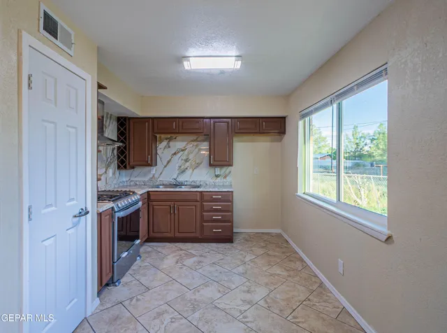 a large kitchen with a stove a sink dishwasher and a refrigerator