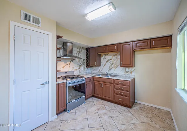 a kitchen with granite countertop a sink and a stove