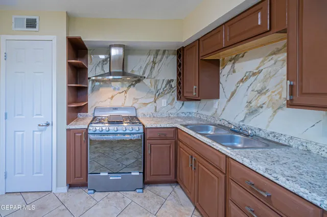 a kitchen with granite countertop a sink and cabinets