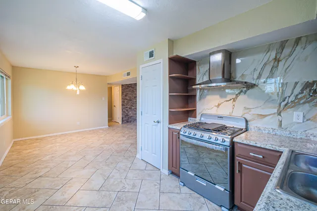 a kitchen with stainless steel appliances granite countertop a stove a refrigerator and a oven