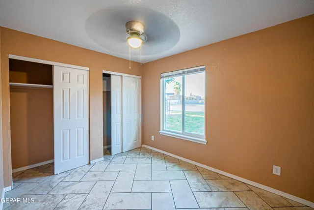 an empty room with windows and closet