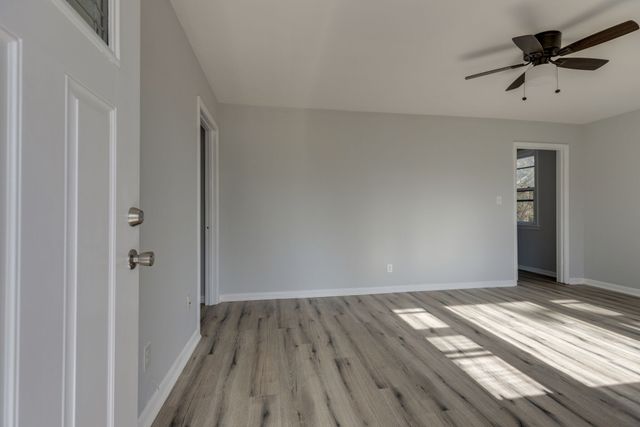 a view of a big room with wooden floor and a ceiling fan