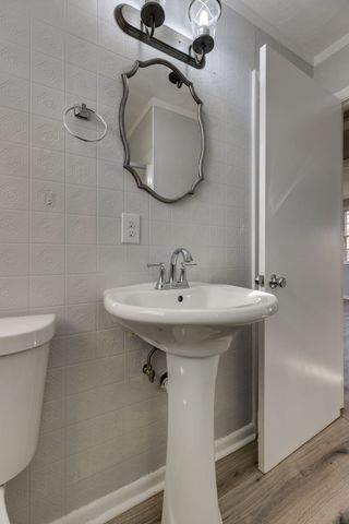 a bathroom with a sink toilet and mirror