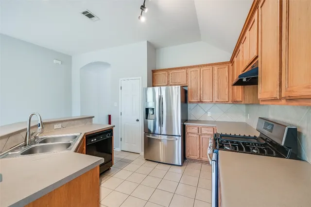 a kitchen with stainless steel appliances a refrigerator sink and microwave