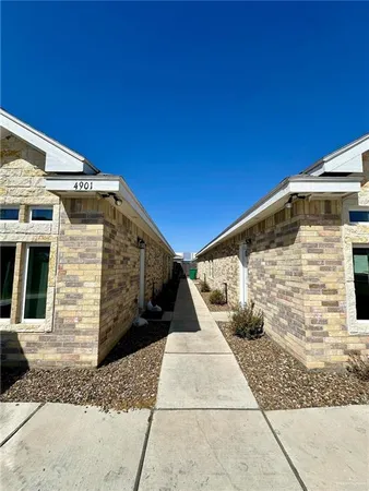 a living room with couches and kitchen view with wooden floor