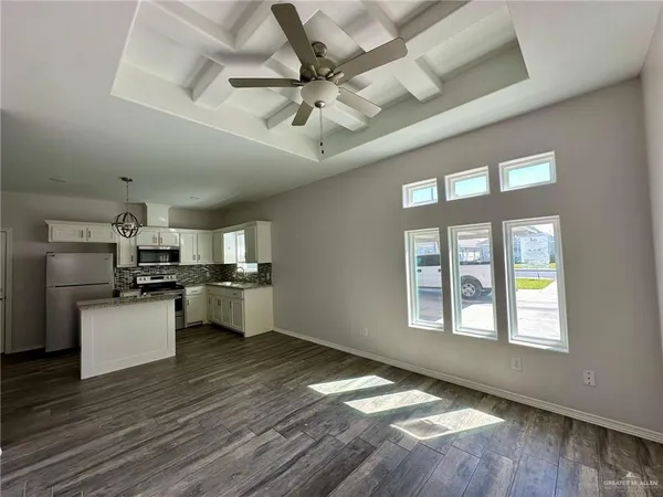 a kitchen with stainless steel appliances a refrigerator and wooden floor