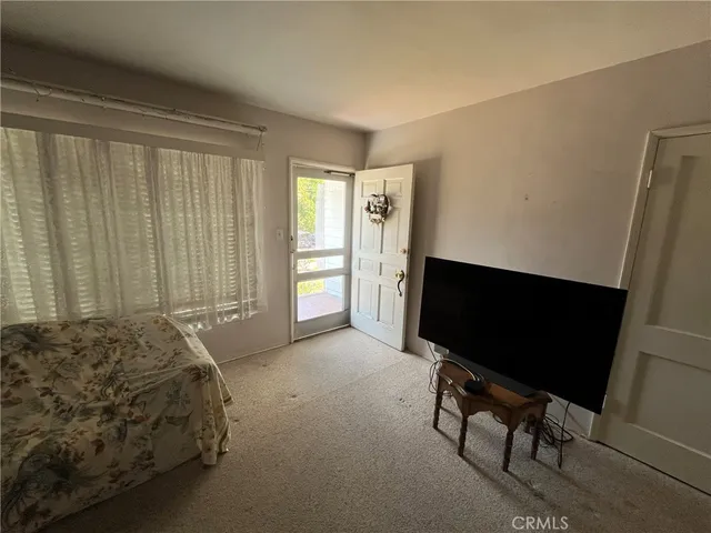 a bedroom with a bed tv and a chair