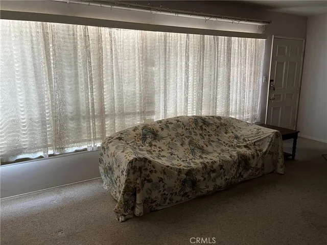 a bed sitting in a bedroom next to a window