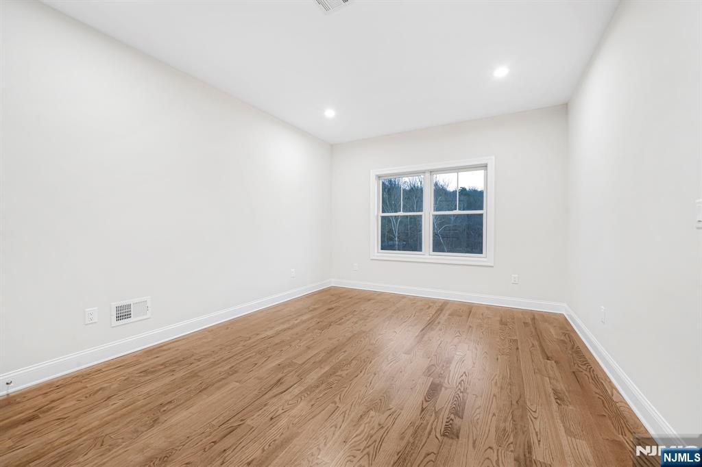 18 Birdie Lane Boonton, NJ 07005 - Photo 16 of 36 an empty room with wooden floor and windows