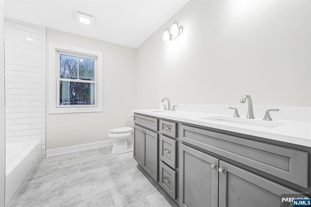 18 Birdie Lane Boonton, NJ 07005 - Photo 22 of 36 a spacious bathroom with a toilet sink and mirror