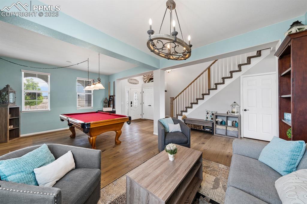 1465 Bowstring Road Monument, CO 80132 - Photo 13 of 49 a living room with furniture and a chandelier