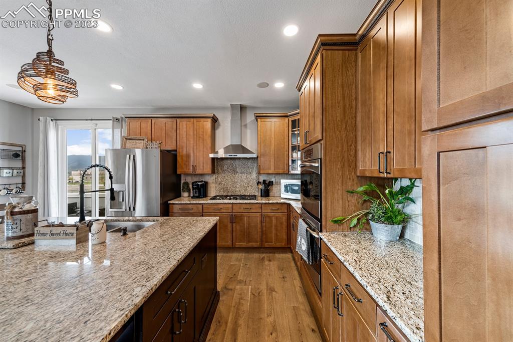 1465 Bowstring Road Monument, CO 80132 - Photo 16 of 49 a kitchen with stainless steel appliances granite countertop a sink a stove and a refrigerator